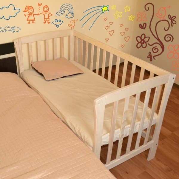 Patut din lemn pentru bebelusi Mos Ene Junior Natur, atasabil atasa la patul parintilor, cu o laterala detasabila, transformabil in pat junior, suport de saltea reglabil pe 3 nivele, adaptabil la inaltimea patului parintilor