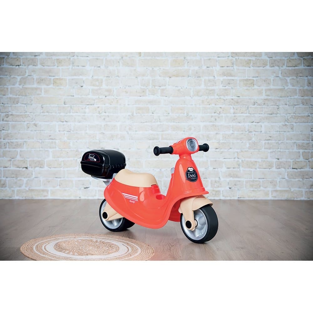 Scuter pentru copii fara pedale Smoby Scooter Ride-On Food Express rosu, dotat cu cheie ce imita pornirea reala a scuterului, recomandat copiilor incepand de la 1,5 ani, spatiu de depozitare sub sezut